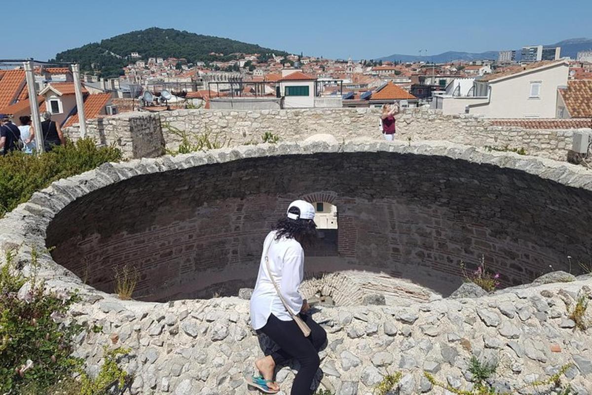 žena kráčející po cihlové zdi a dívající se na město