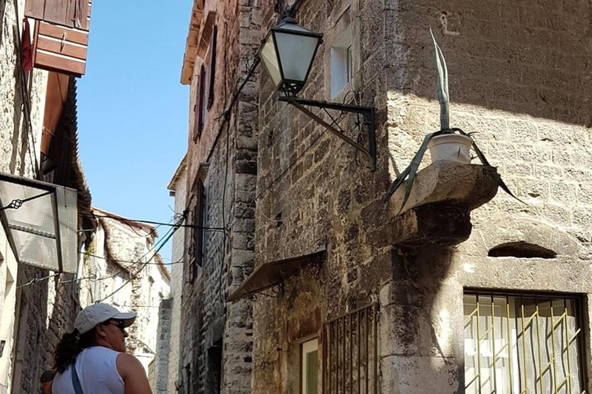 žena kráčející po ulici se světlem na budově