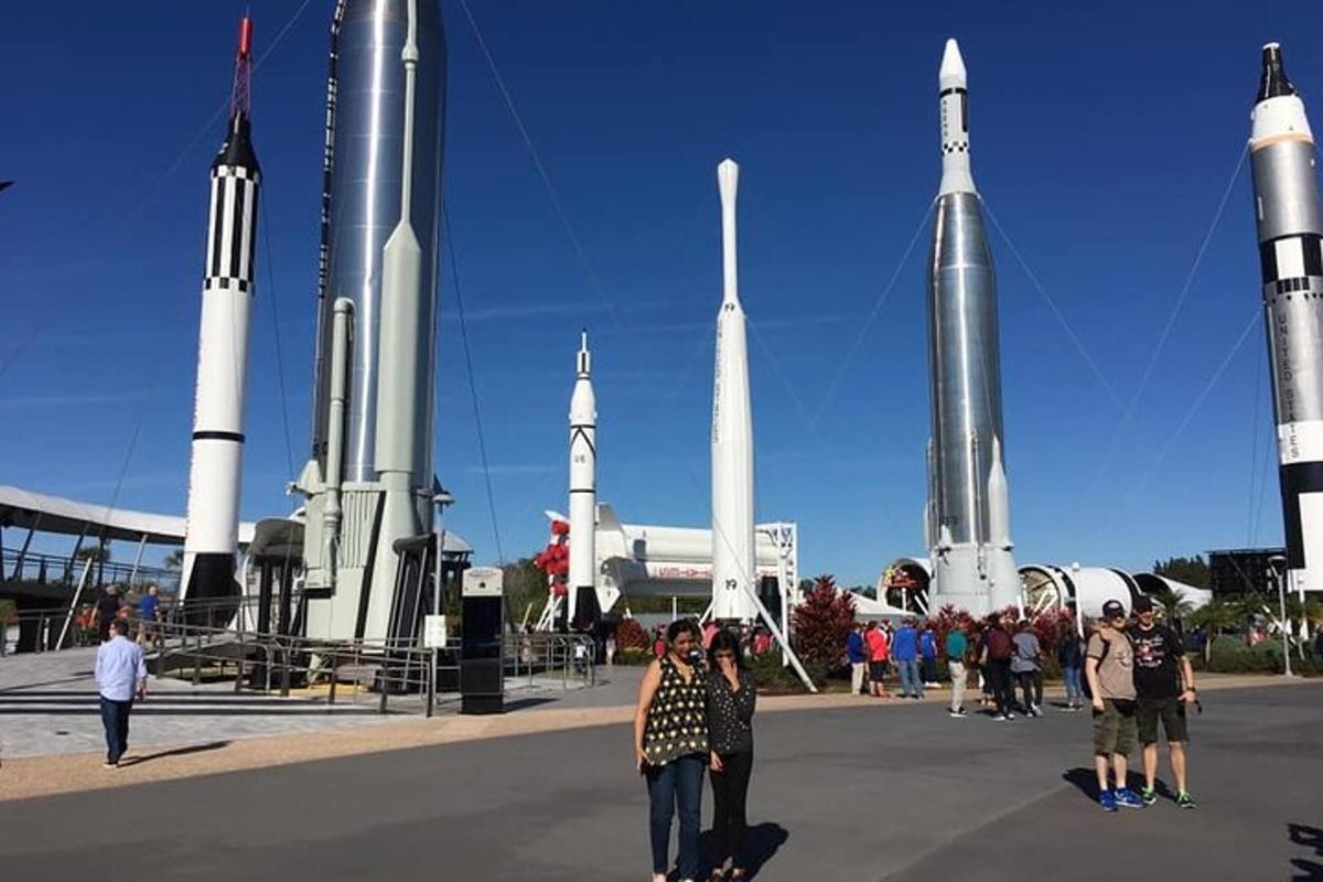 skupina lidí stojících před raketami