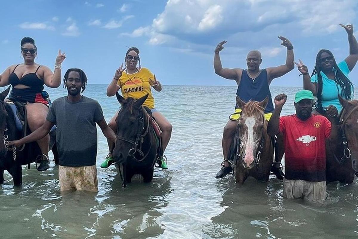 een groep mensen die op paarden in het water rijden