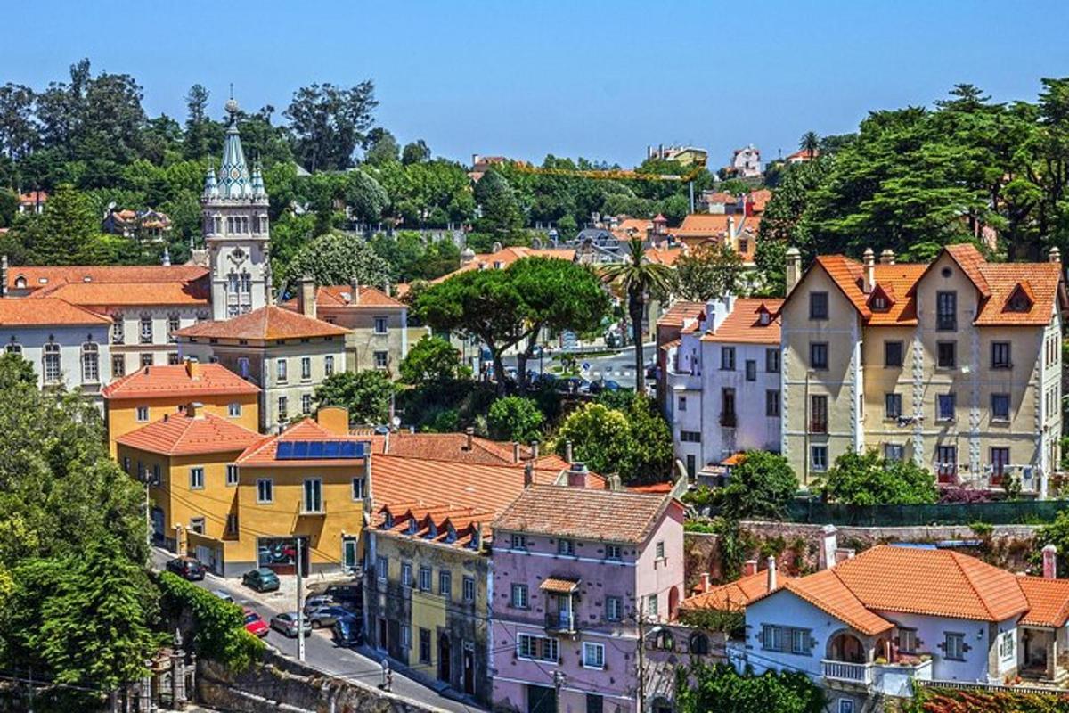 μια πόλη με σπίτια και έναν πύργο ρολογιού σε έναν λόφο