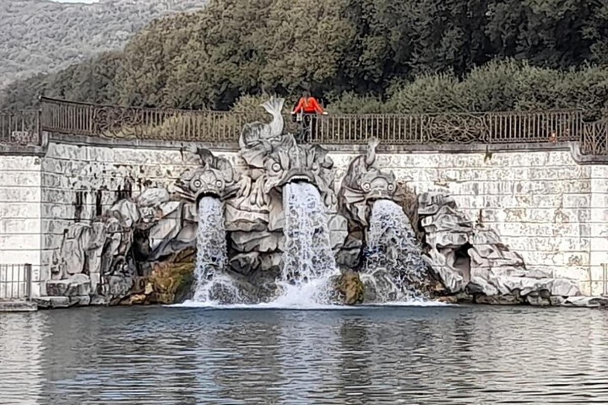 un uomo in piedi su un ponte sopra una fontana