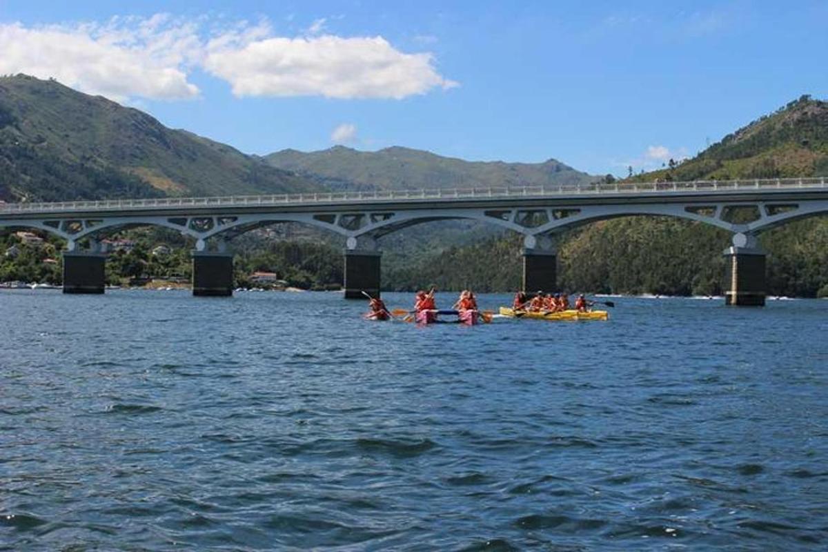un gruppo di persone sui kayak nell'acqua sotto un ponte