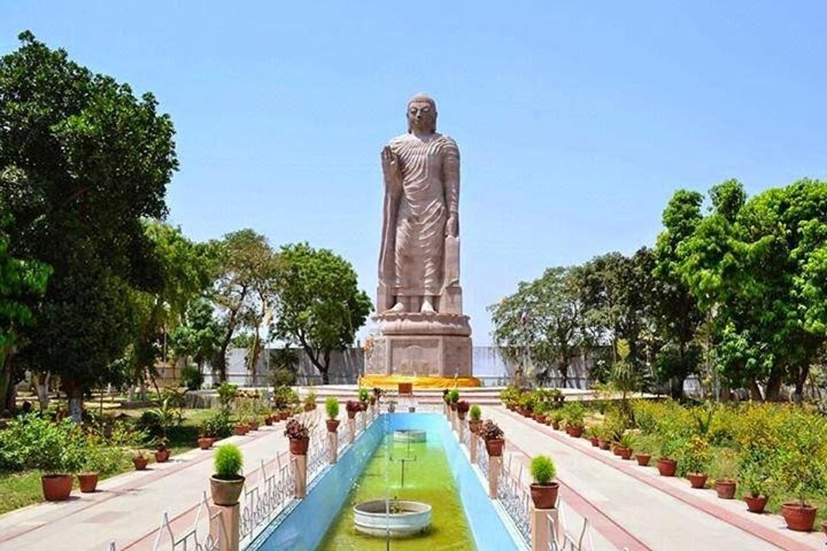 una statua in un parco con una fontana di fronte