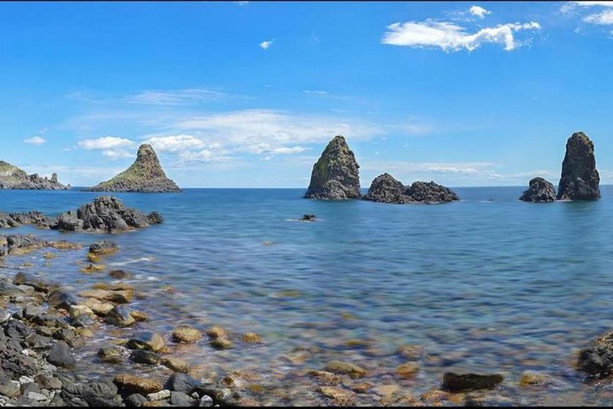 a group of rocks in the water near the shore
