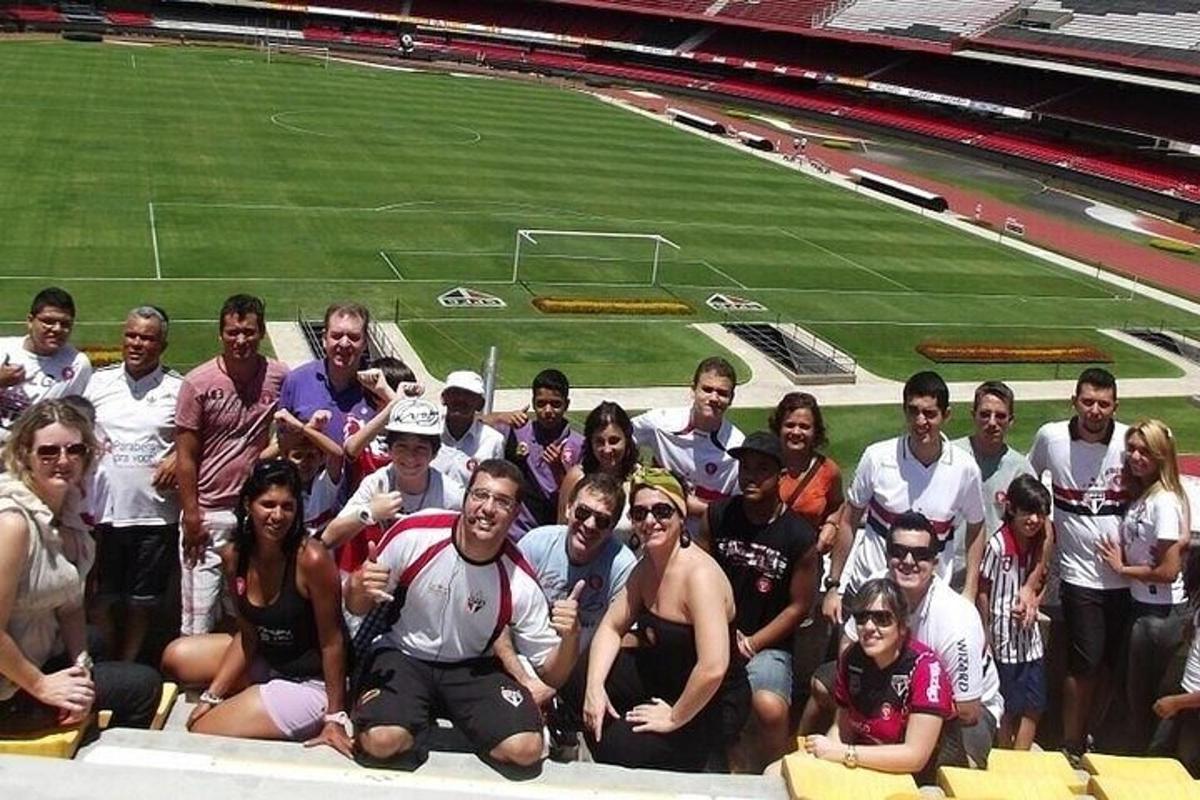 a group of people posing in front of a soccer field
