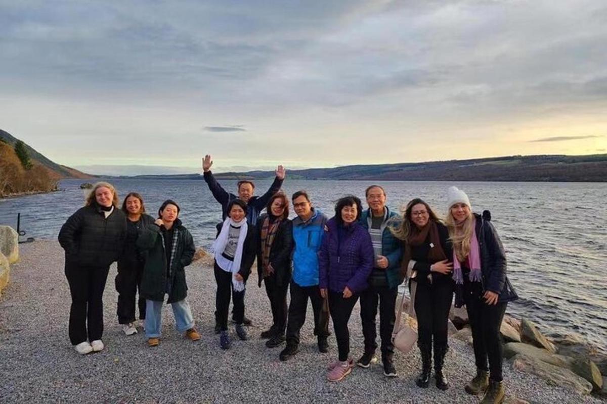 a group of people standing next to a body of water