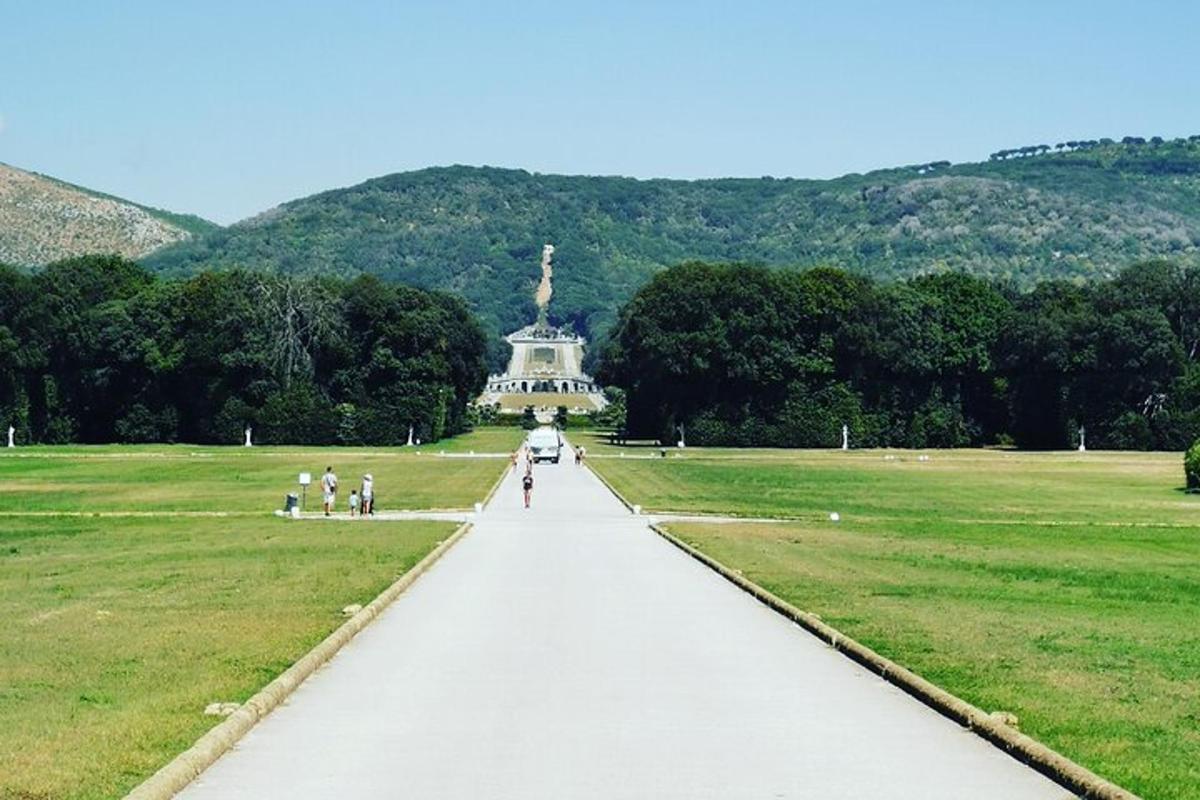una passerella attraverso un parco con una statua in lontananza