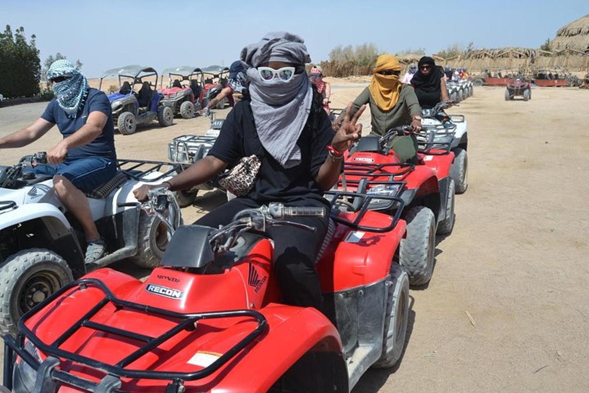 un gruppo di persone in sella a quad nel deserto