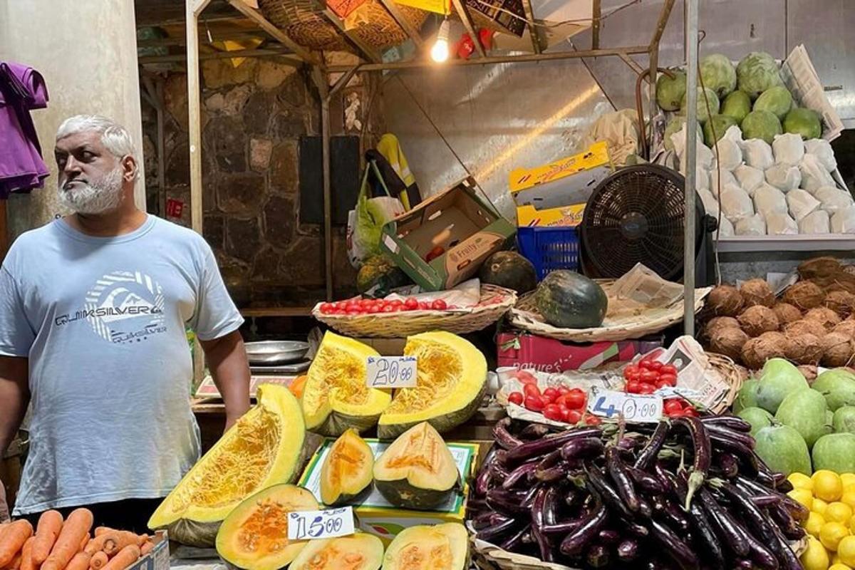 muž stojící před trhem s ovocem a zeleninou