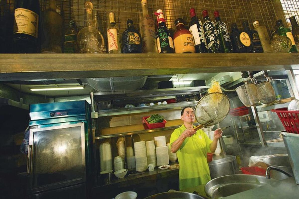 una donna in piedi in cucina che tiene in mano una pentola