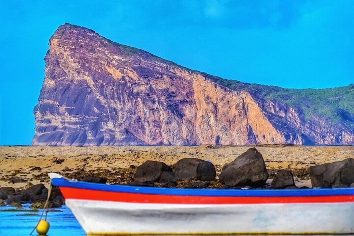 una barca sulla spiaggia con una montagna sullo sfondo