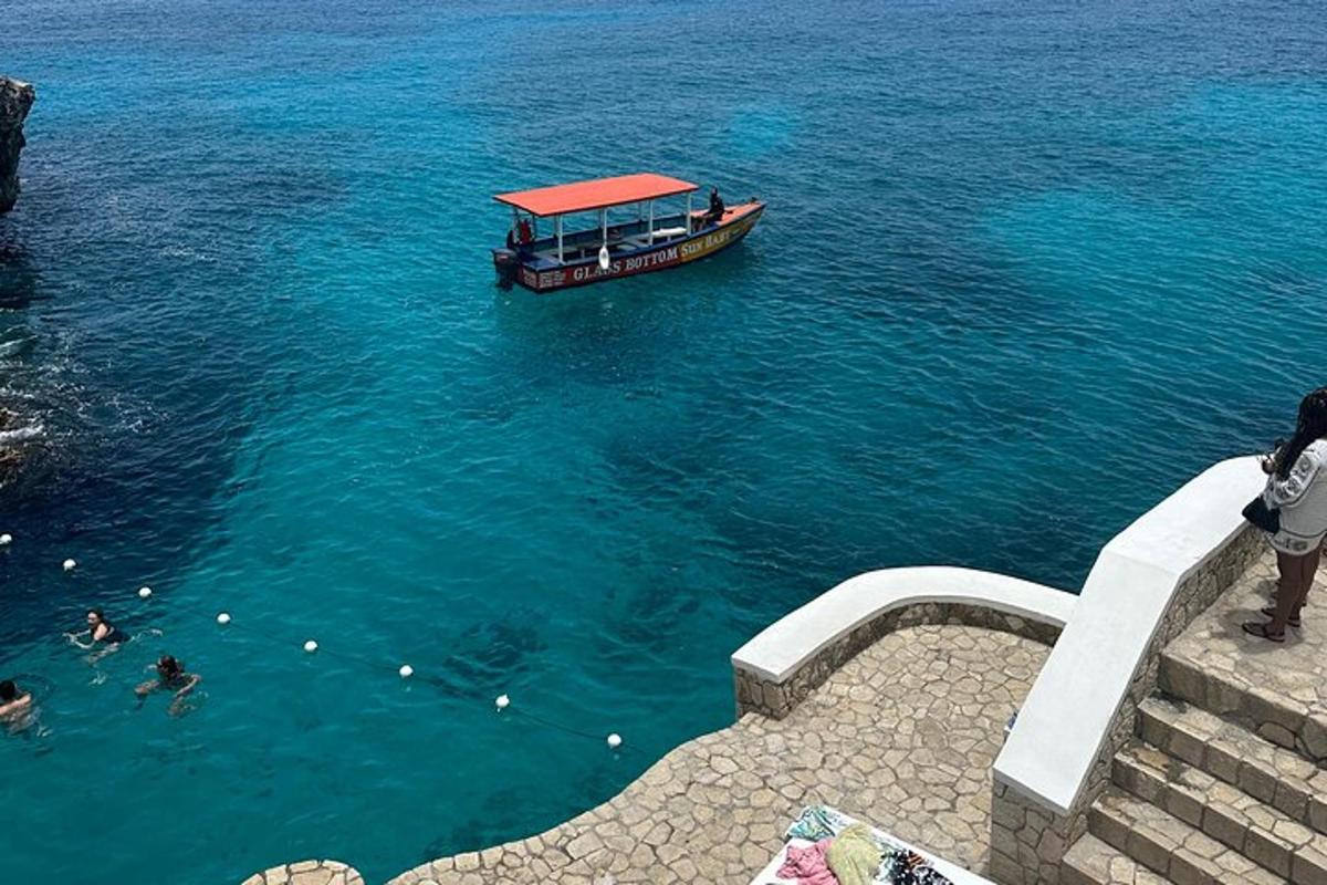 a boat in the water with people swimming in it