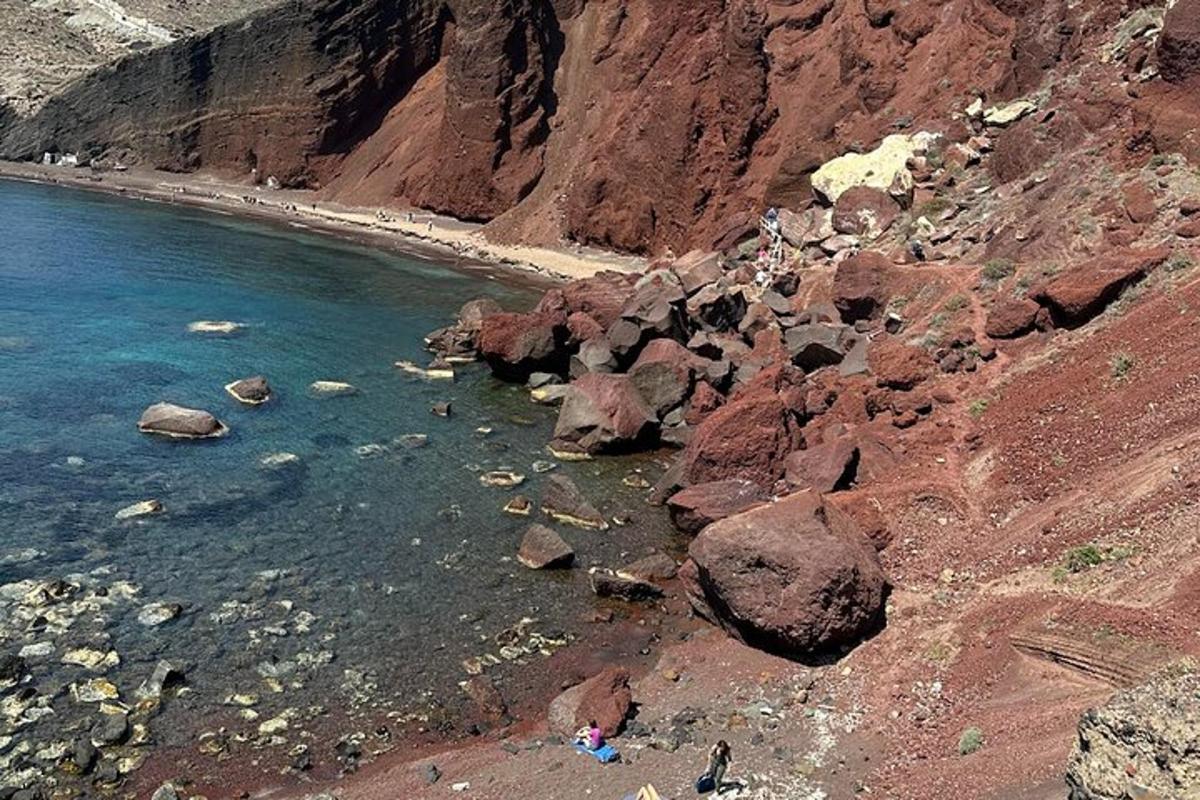 una spiaggia con rocce e persone in acqua