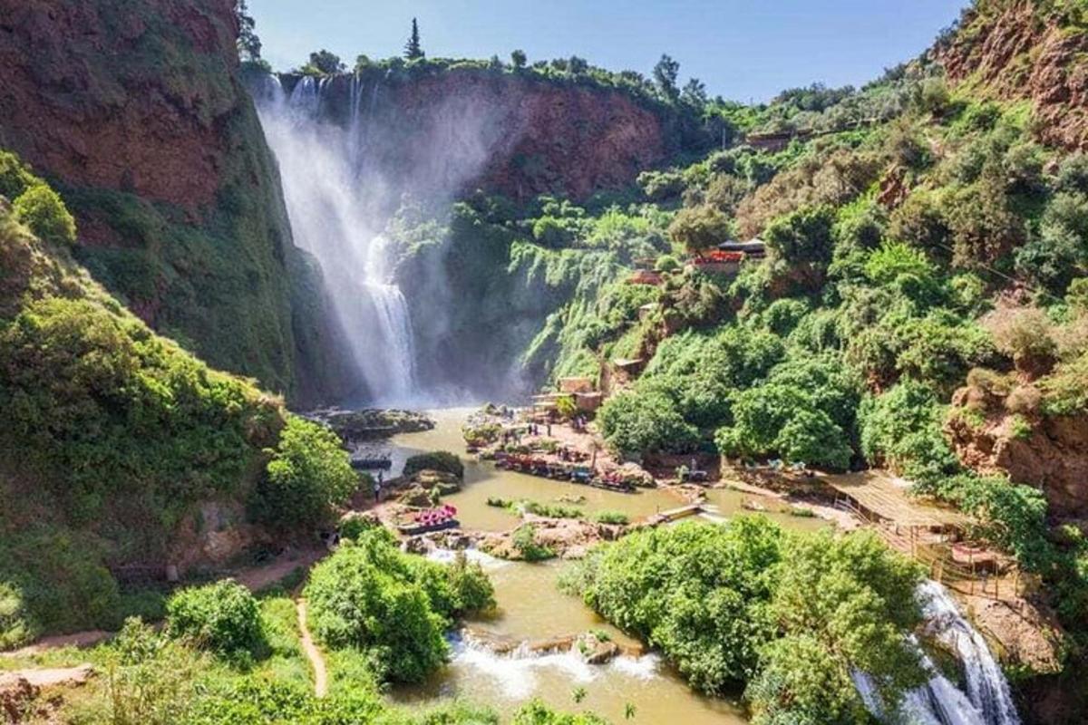 a waterfall in the middle of a canyon with trees