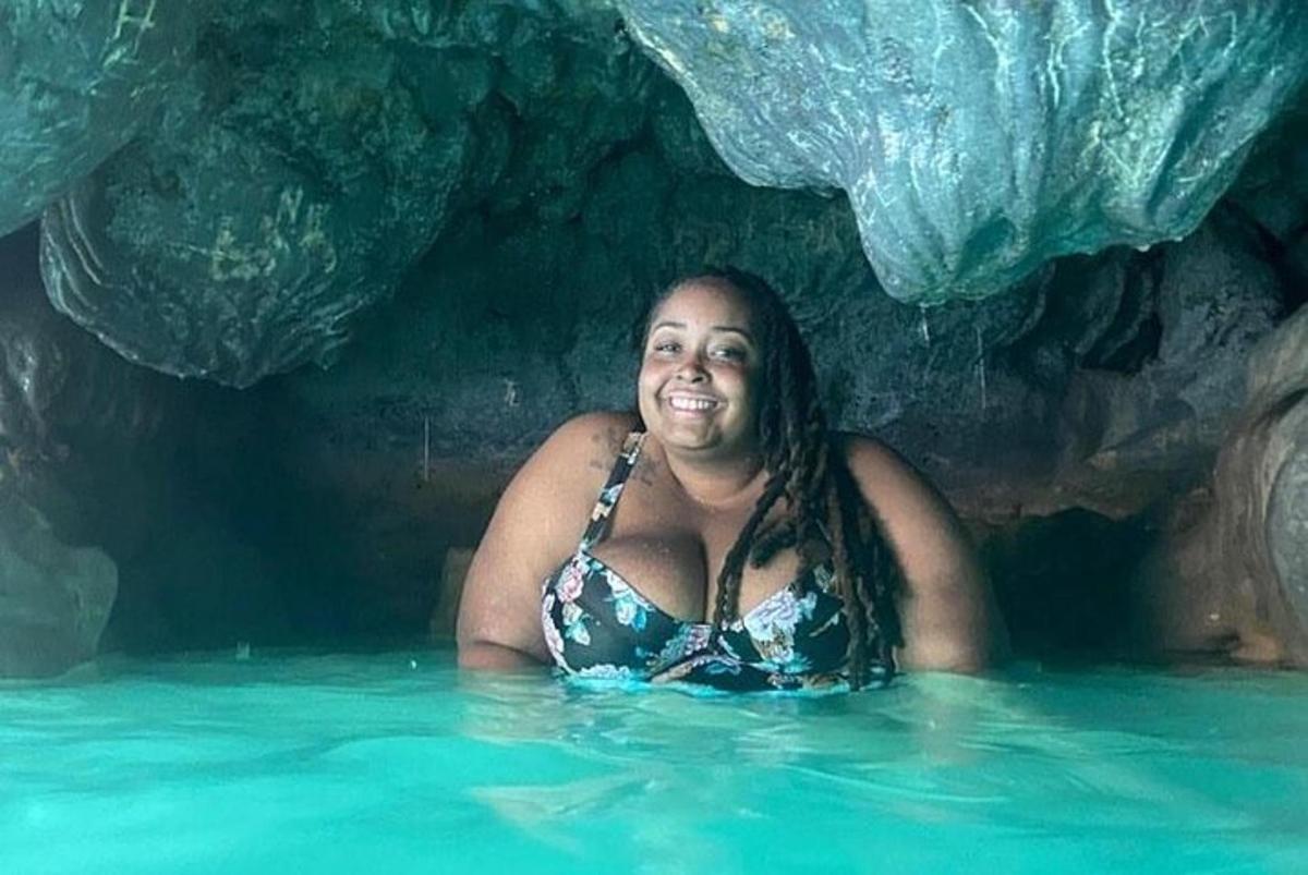 uma mulher em uma piscina em uma caverna