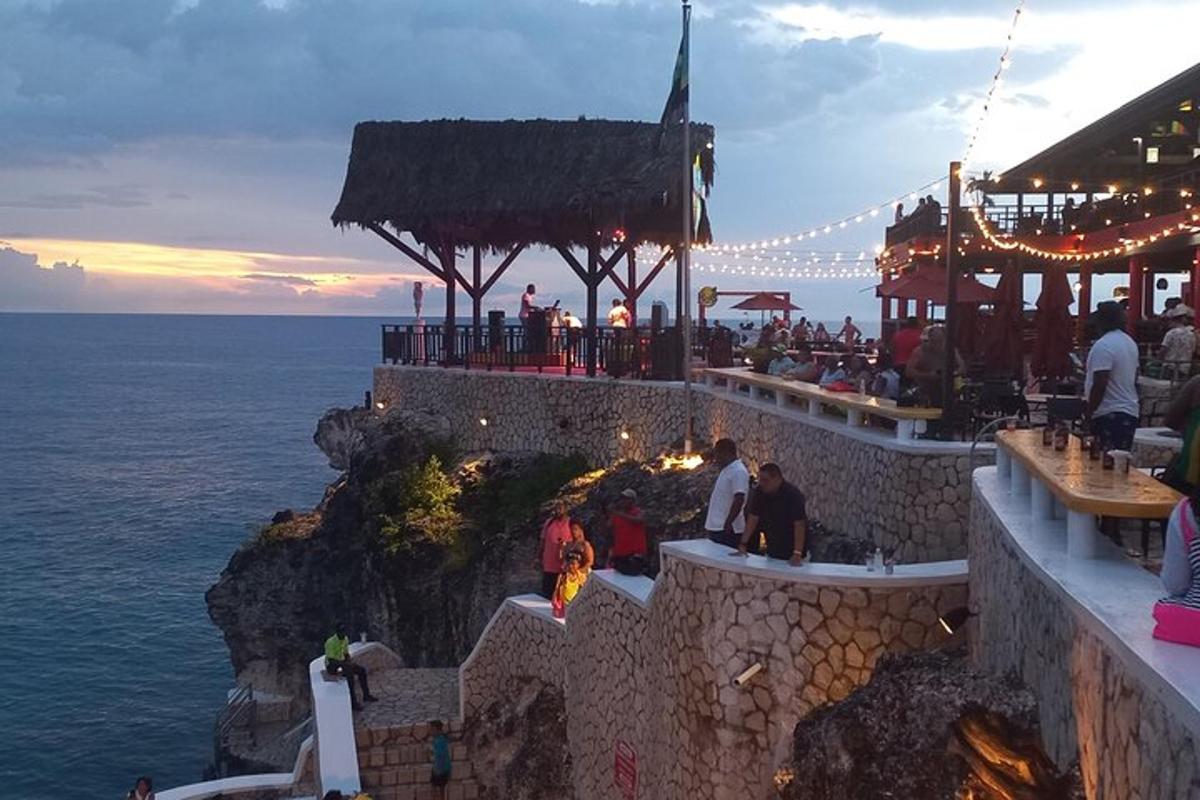 hópur fólks situr í kringum bar á kletti