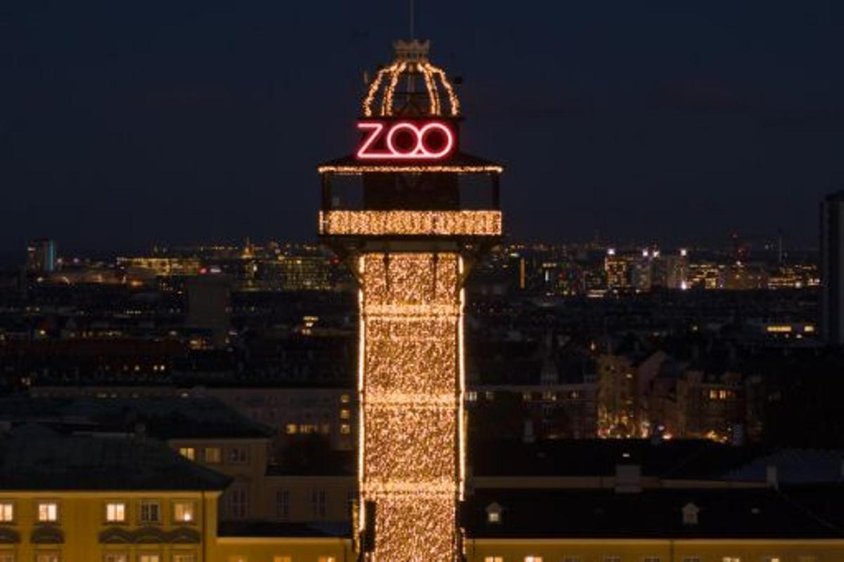 a lit up tower with a clock on top of it