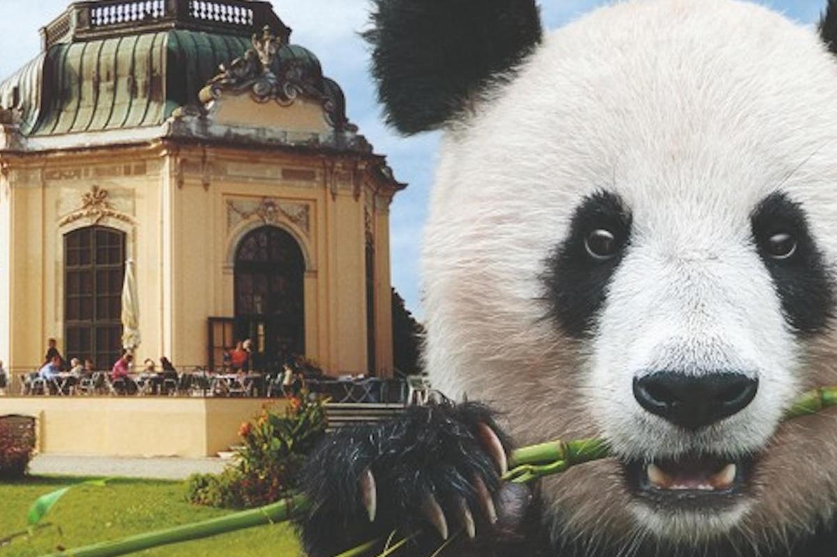 a statue of a panda bear holding a green plant