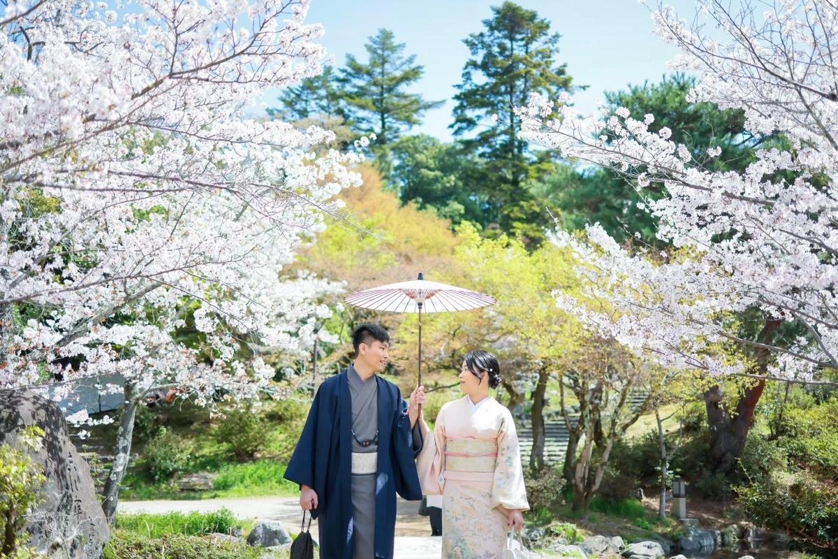 a bride and groom standing under an umbrella
