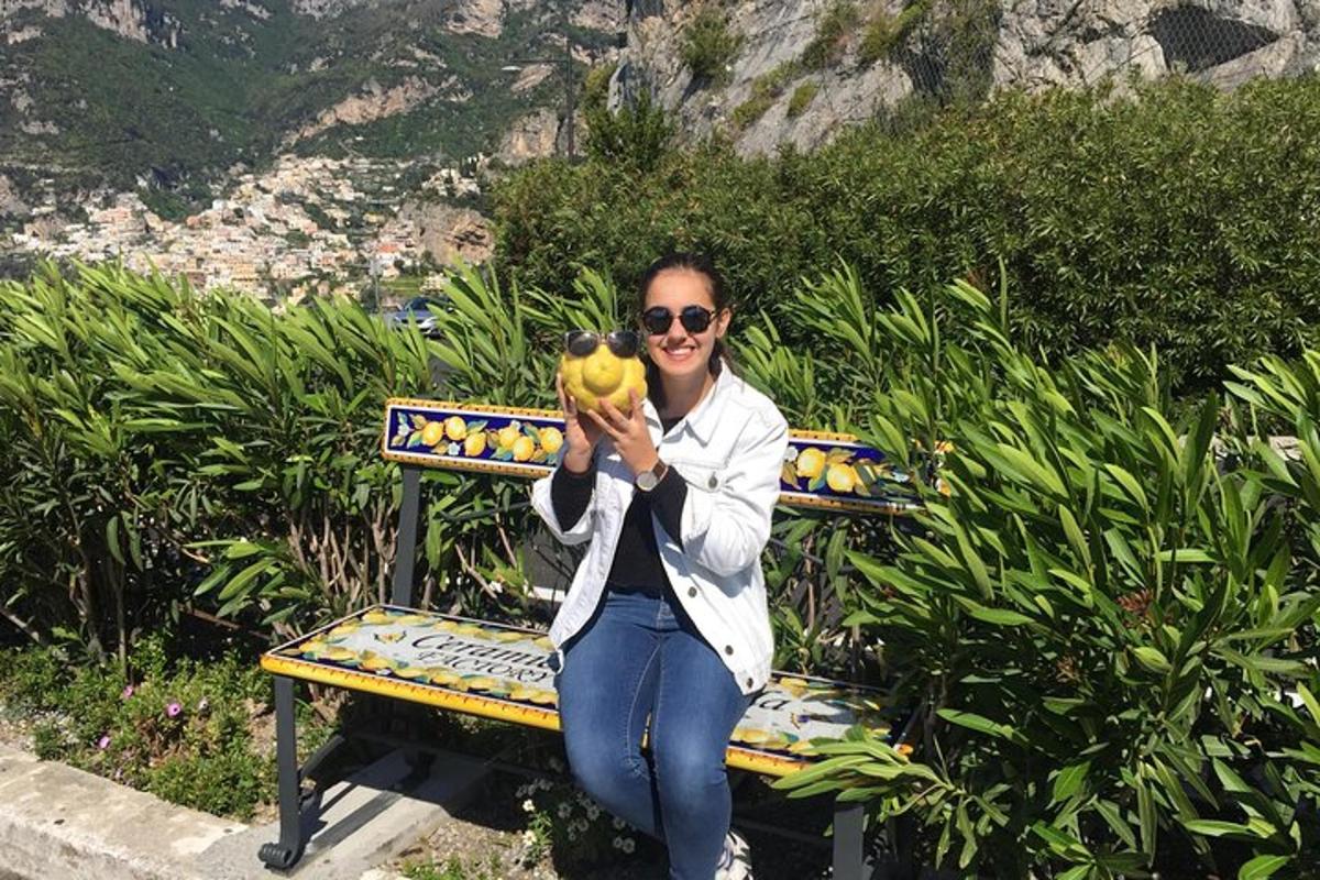 uma mulher sentada em um banco segurando um cacho de bananas
