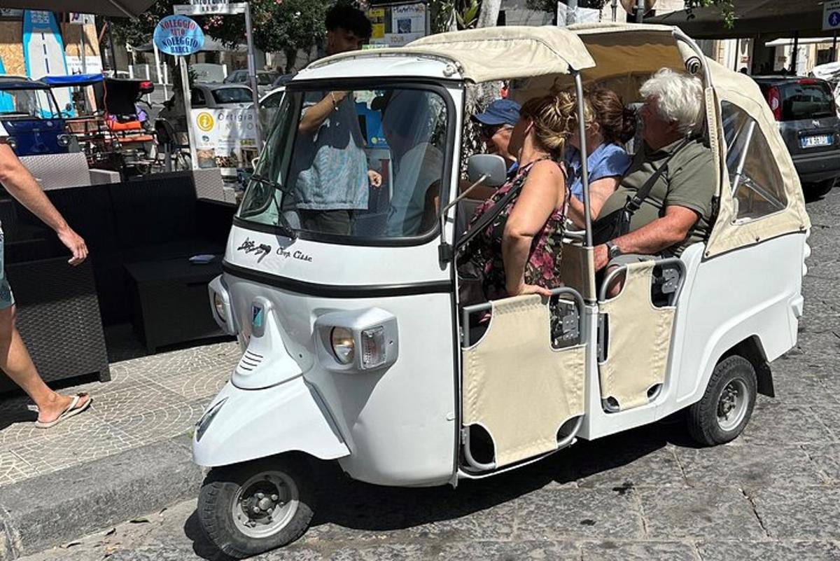 um grupo de pessoas em um pequeno carrinho de golfe
