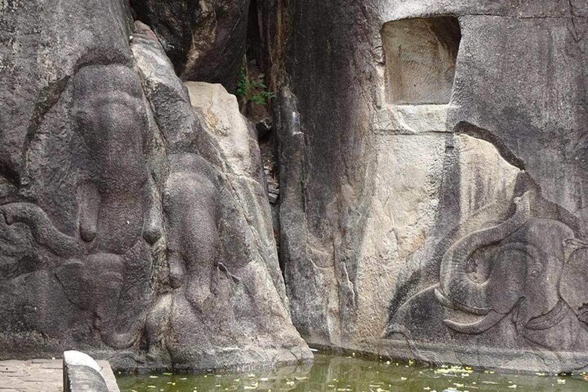 Un muro de piedra con una estatua de un elefante junto al agua.