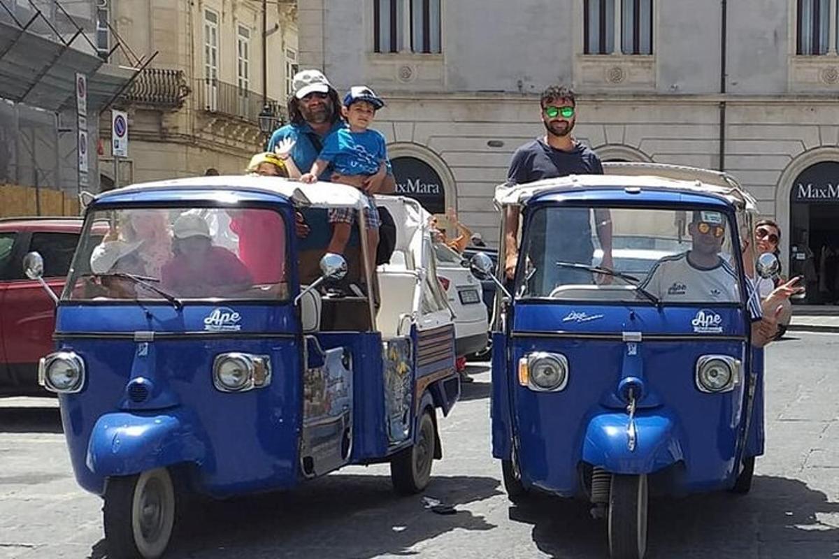 un grup de persones que viatjaven a la part posterior d'un vehicle petit