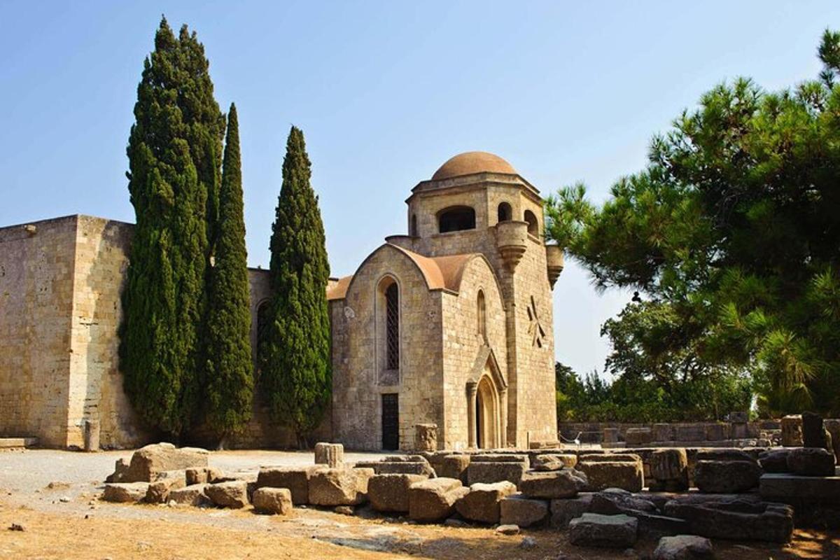 Una antigua iglesia de piedra con una torre y árboles.