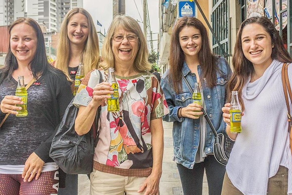 sekumpulan wanita berdiri bersama sambil memegang minuman