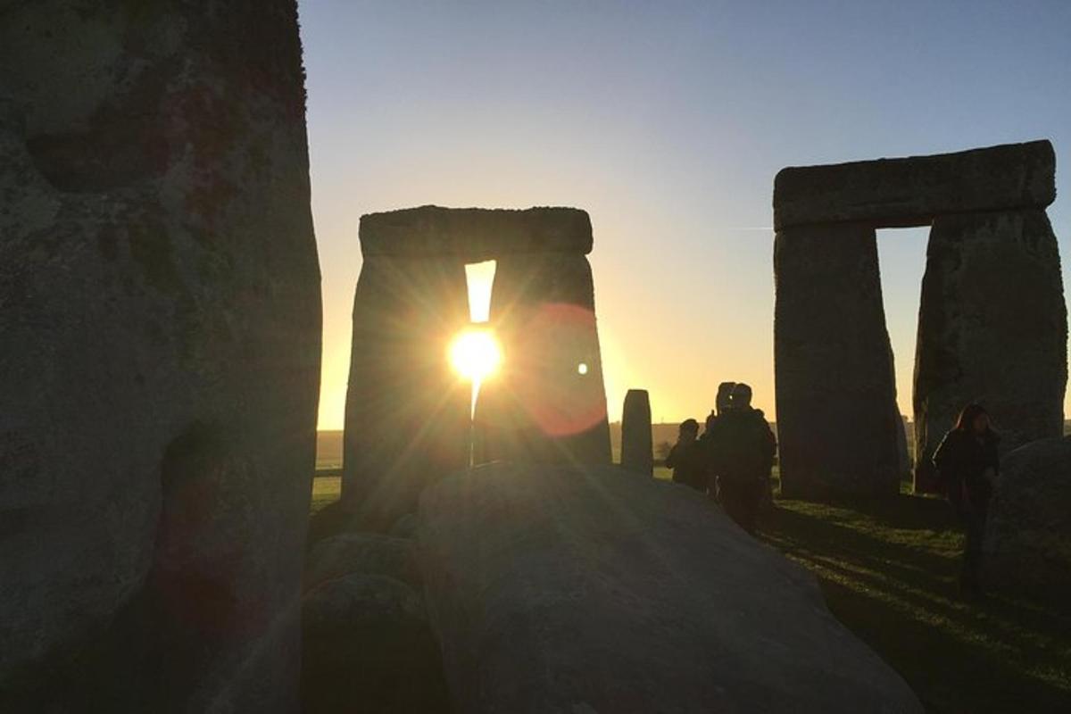 člověk fotí západ slunce u Stonehenge