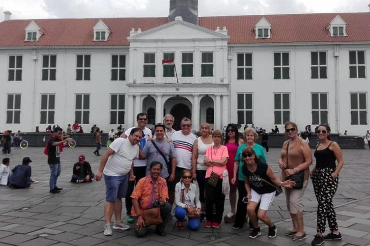 skupina lidí pózujících před bílou budovou