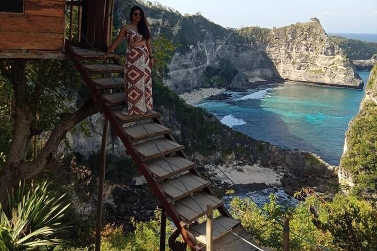 een vrouw staand op een ladder met uitzicht op de oceaan