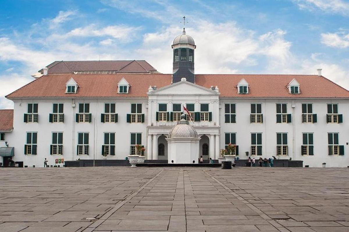 sebuah bangunan besar berwarna putih dengan menara jam di atasnya