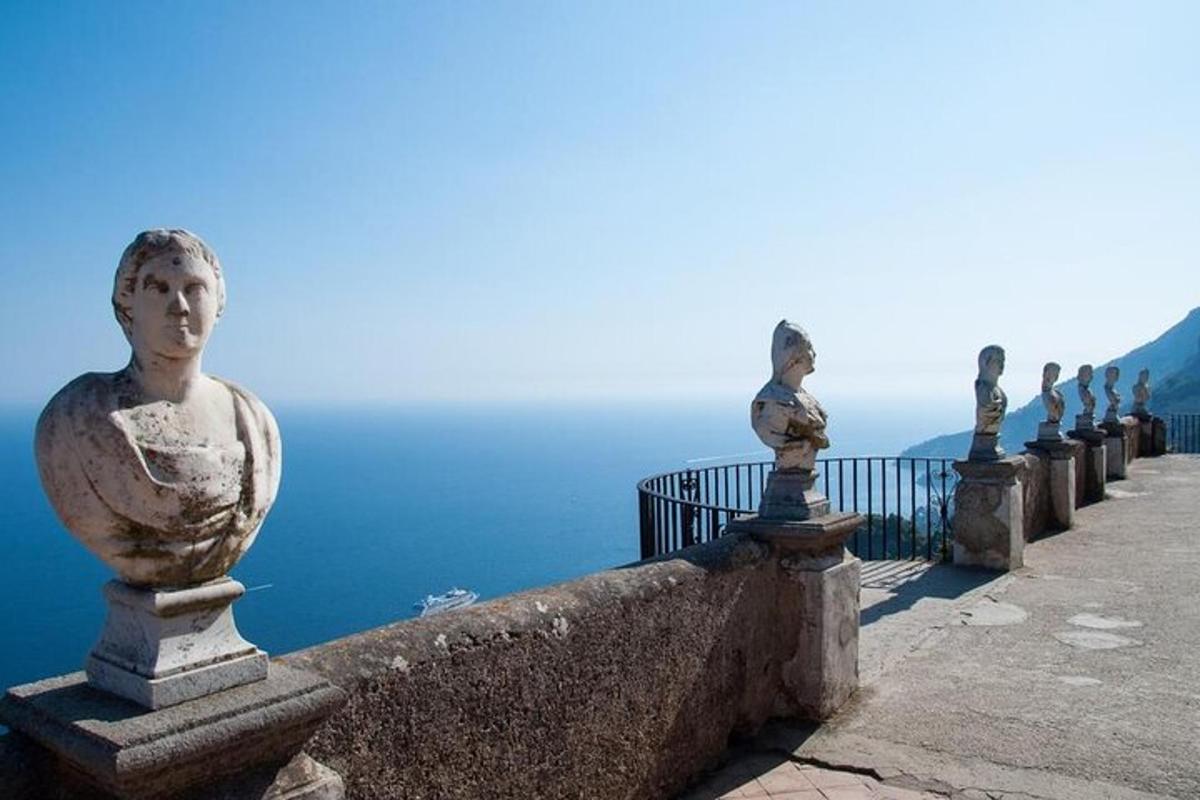 una fila de estatuas en una pared cerca del océano