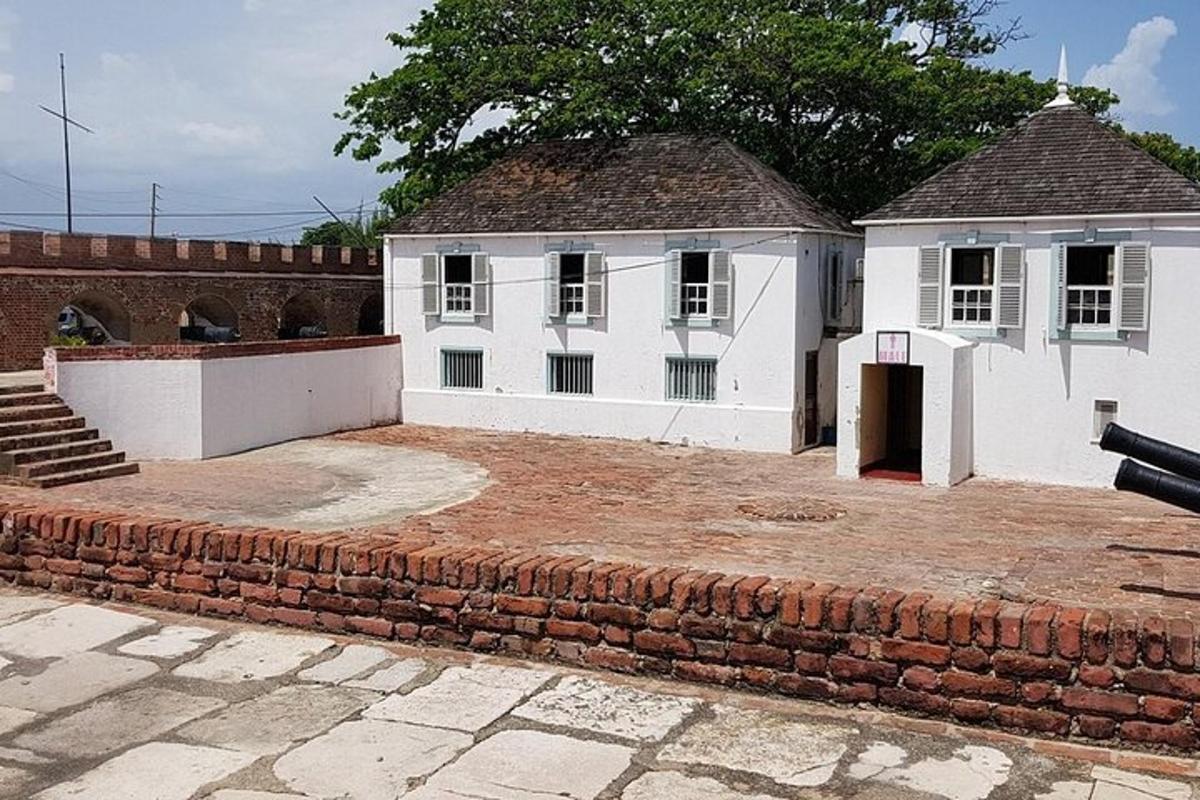 un edificio bianco con un muro di mattoni di fronte