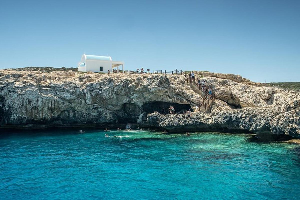 un gruppo di persone che nuotano nell'acqua vicino a una scogliera