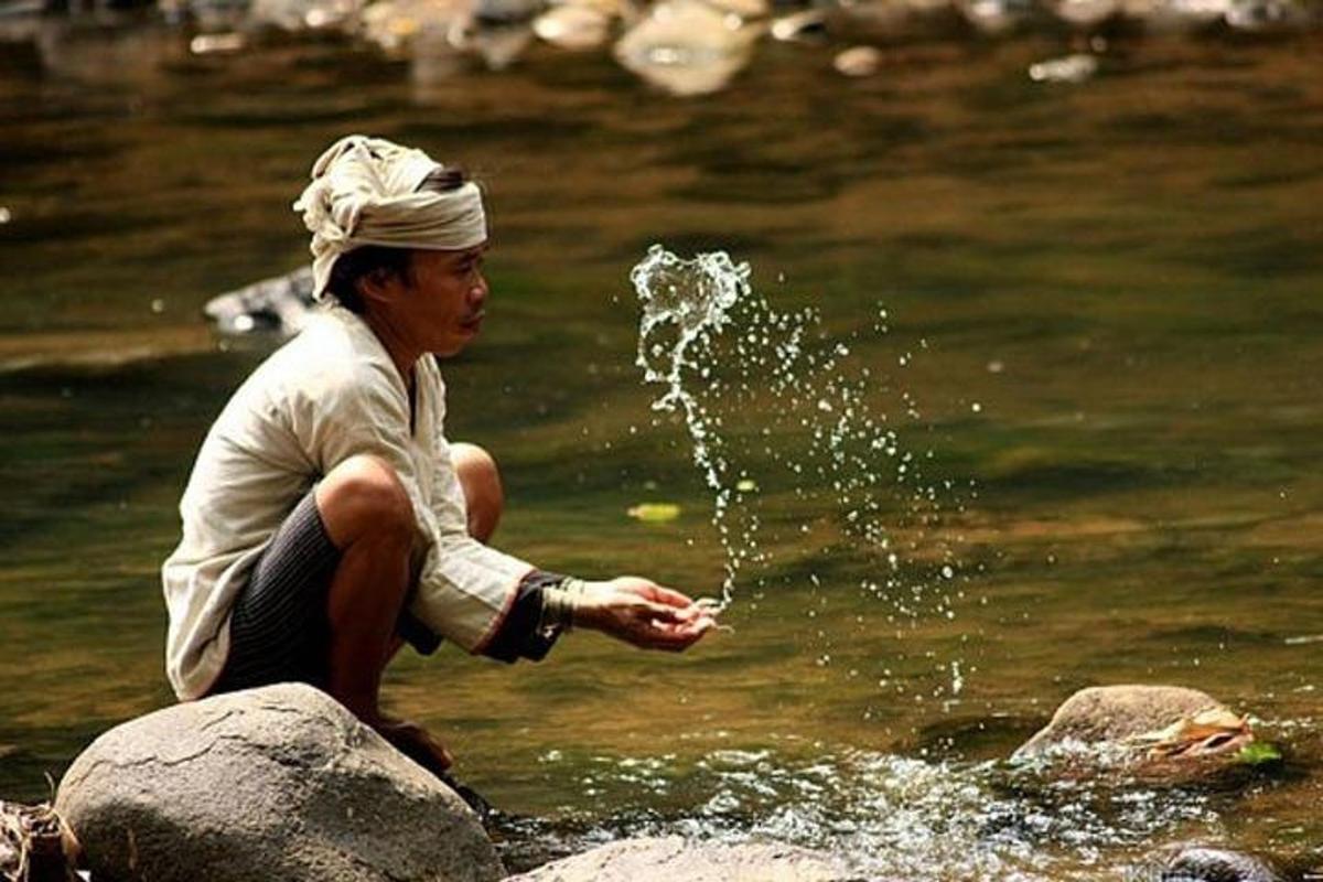 eine Person, die auf einem Felsen im Wasser sitzt