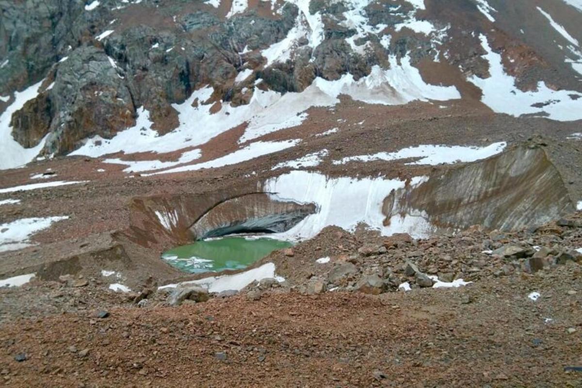 una muntanya coberta de neu amb una massa d'aigua