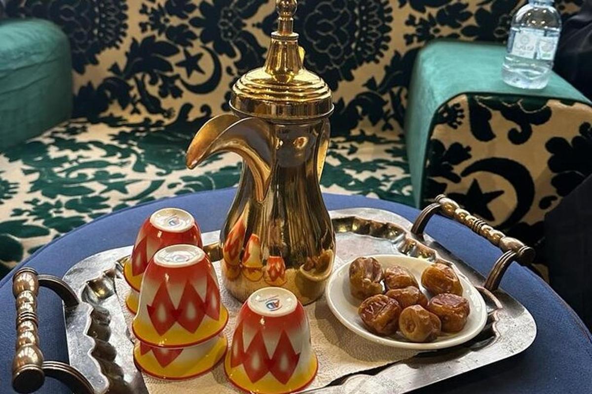 a table with a tea kettle and a plate of donuts
