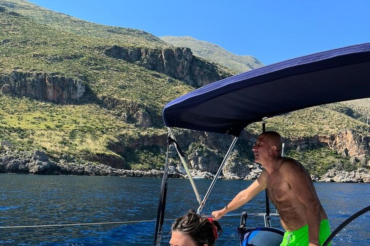 一名身穿绿色短裤的男子在水中的船上