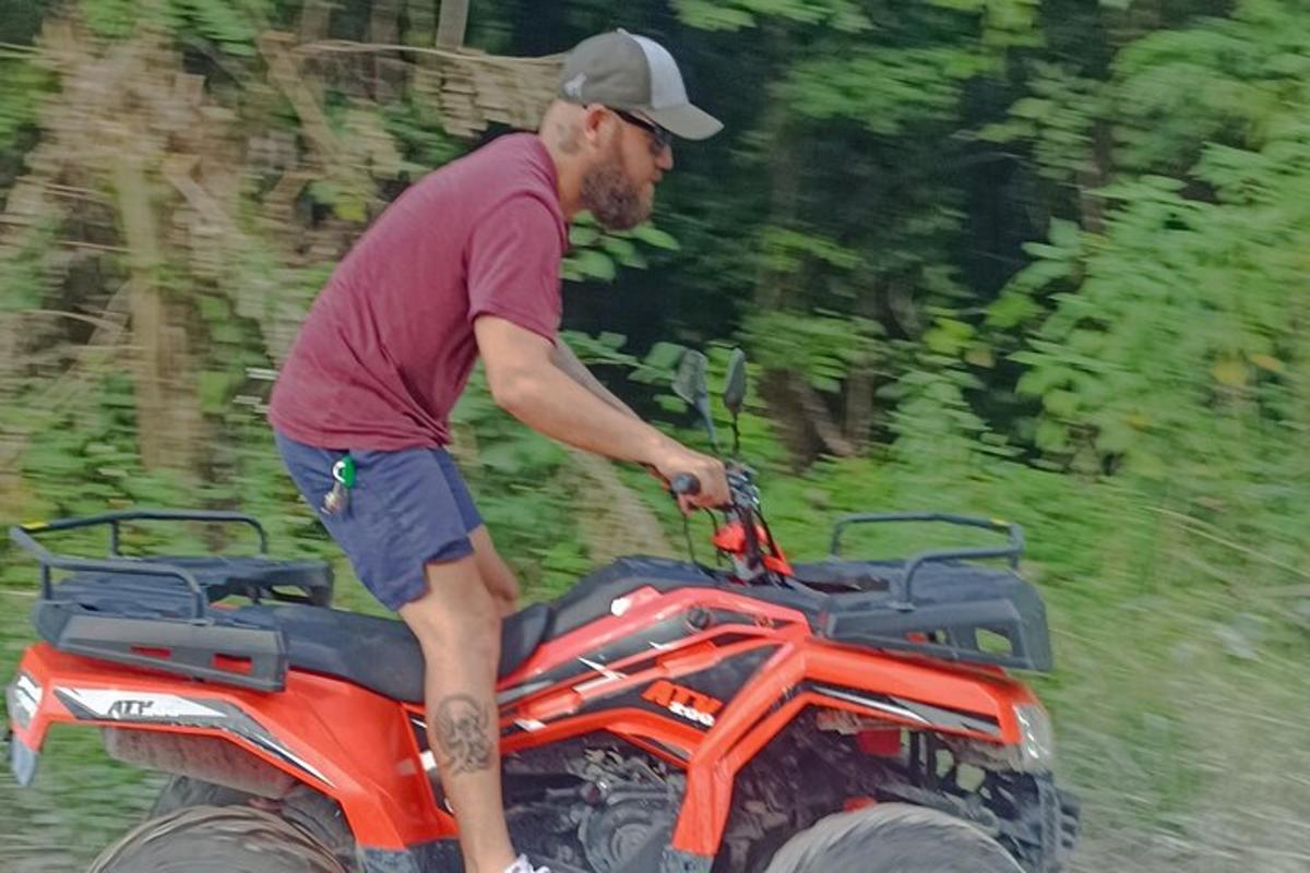 muž stojící na zadní straně čtyřkolky