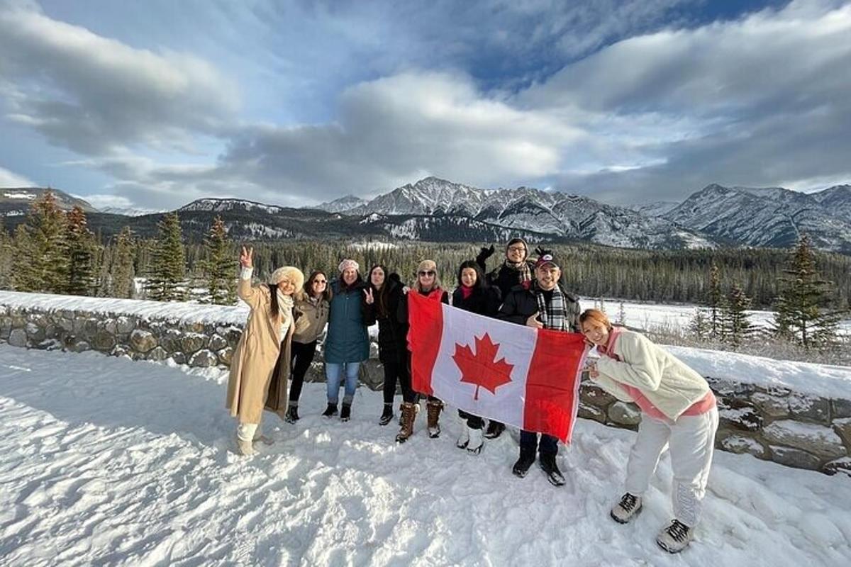 isang grupo ng mga tao na nakatayo sa niyebe na may hawak na watawat ng canadian
