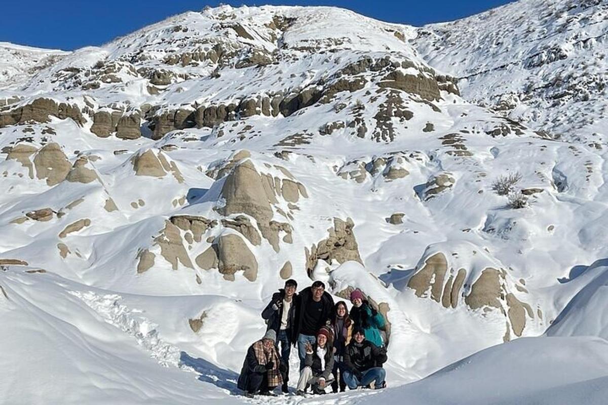 un grup de persones dempeus en una muntanya coberta de neu