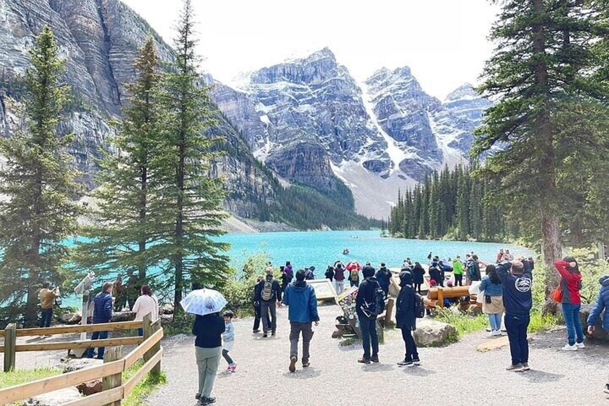 un grup de persones caminant al voltant d'un llac amb muntanyes