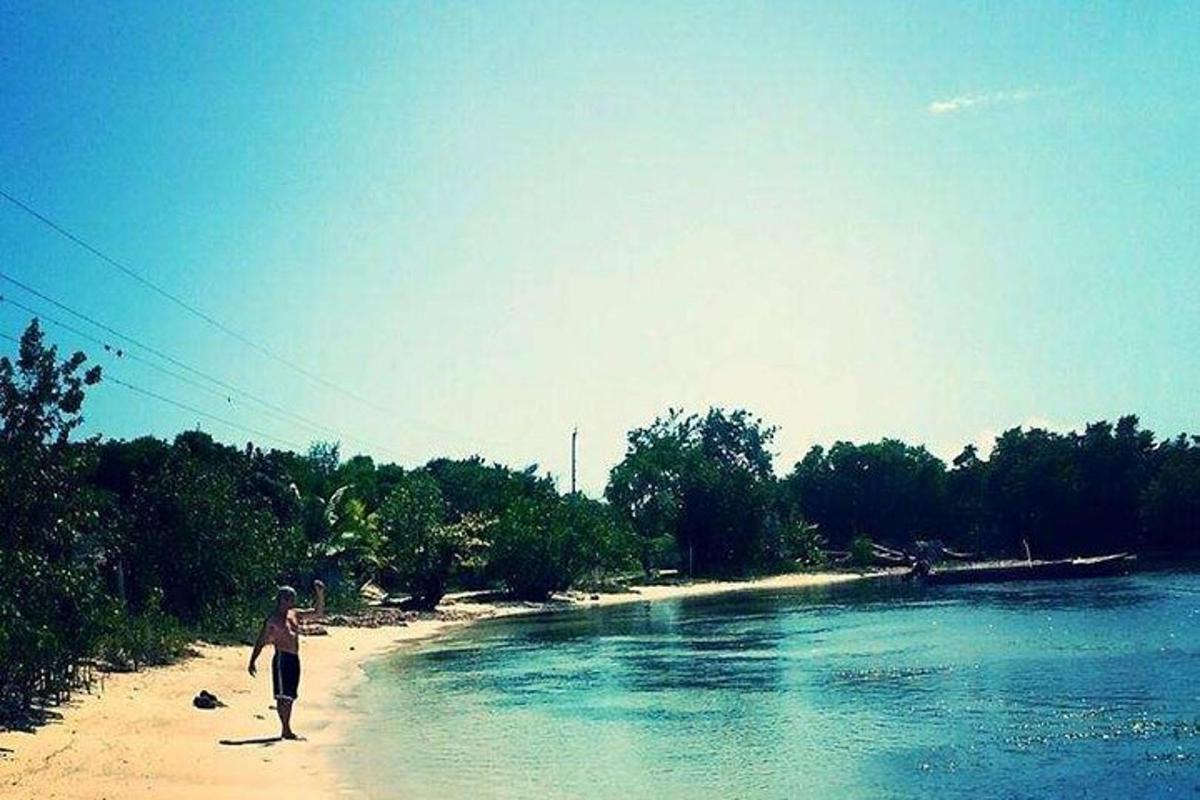 en mann som går på en strand nær en elv