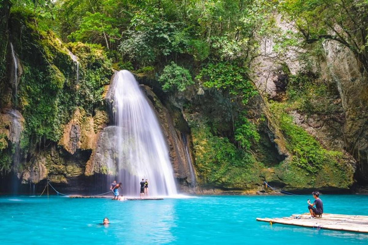 orang di dalam air di hadapan air terjun