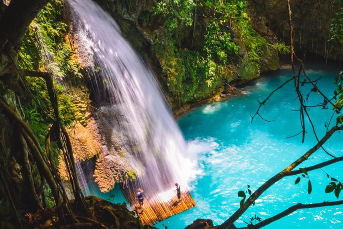 air terjun di dalam hutan dengan orang berdiri di dalam air