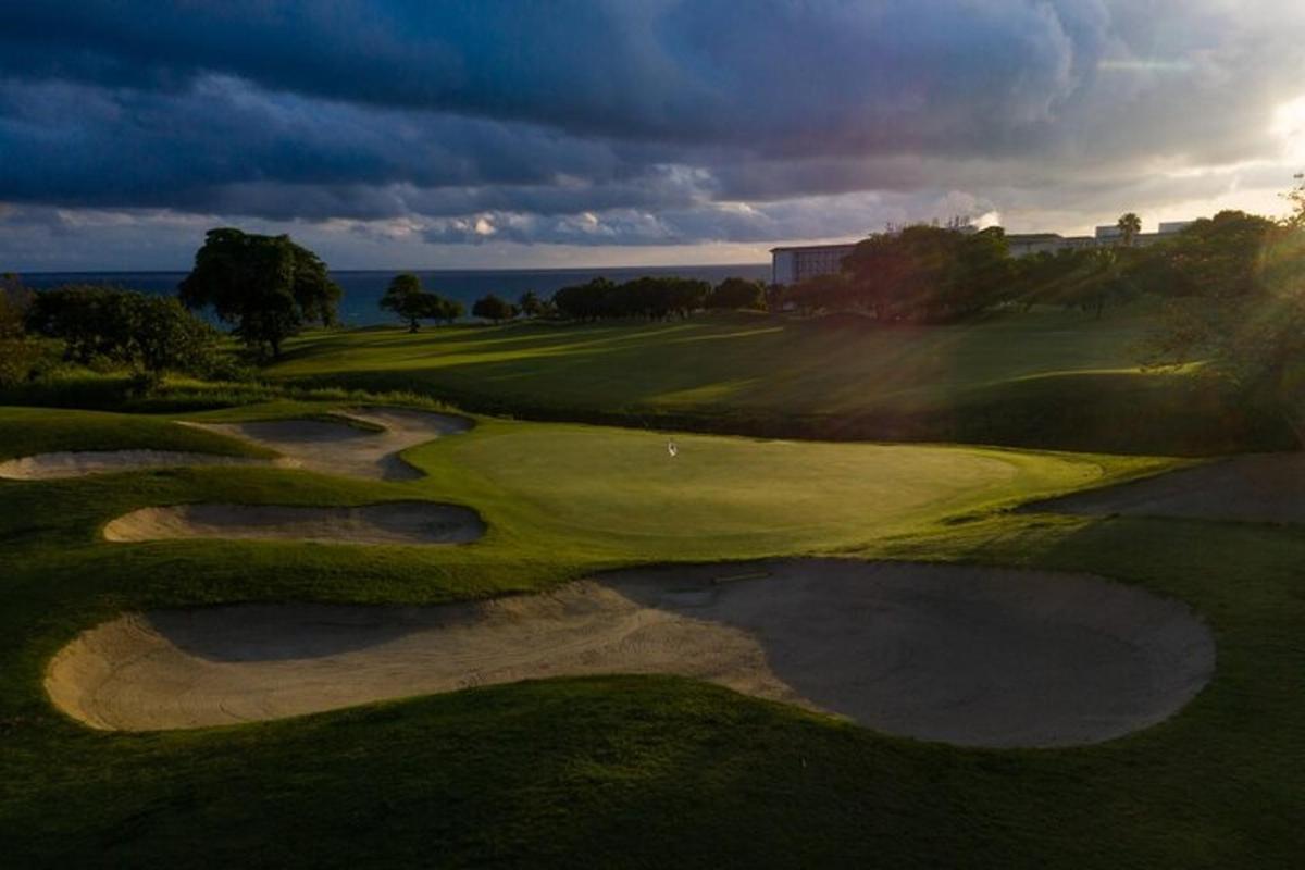 an overhead view of a golf course with a green