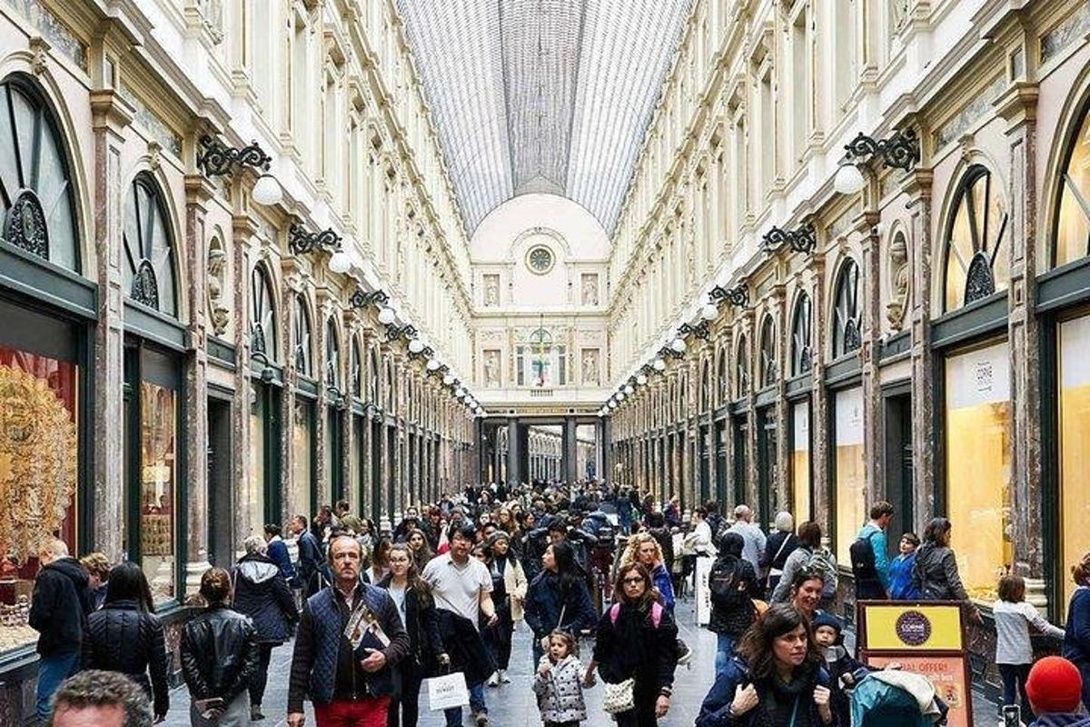 o mulțime de oameni care se plimbă printr-un centru comercial